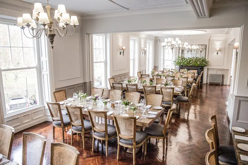 Function room laid for a private dinner beneath chandeliers