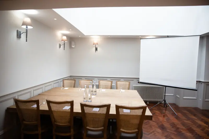 Meeting room set for a boardroom meeting with projector screen
