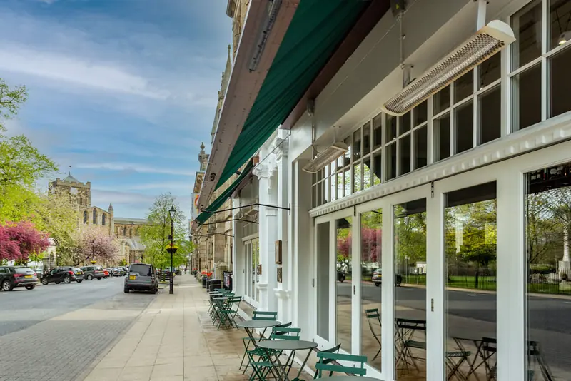 Beaumont Street in spring sunshine with café tables outside the hotel
