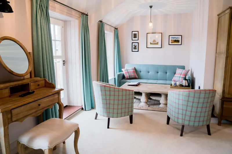 Suite seating area with duck-egg sofa, tartan armchairs and dressing table